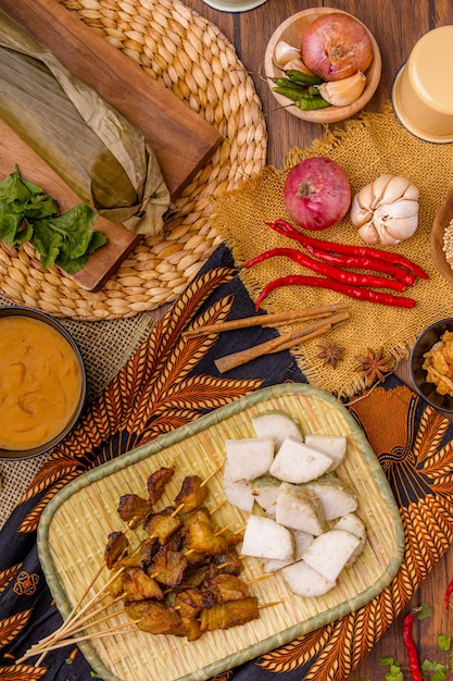 Varkenssaté of Sate Babi Varkenssaté geserveerd met een pittige Padangsaus en plakjes lontong of ketupat rijstwafels gegarneerd met een snufje bawang goreng knapperig gebakken sjalot