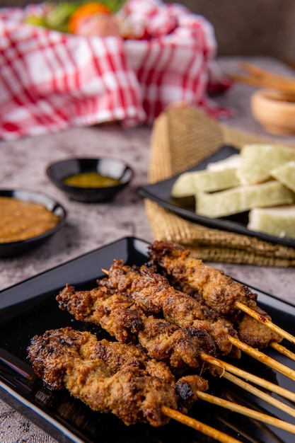 Varkenssaté of Sate Babi Varkenssaté geserveerd met Pindasaus en plakjes lontong of ketupat rijstwafels