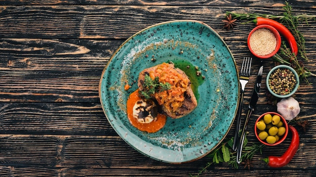 Varkenssteak gegrild met courgette-kaviaar Vlees Bovenaanzicht Op een zwarte houten achtergrond Kopieer de ruimte