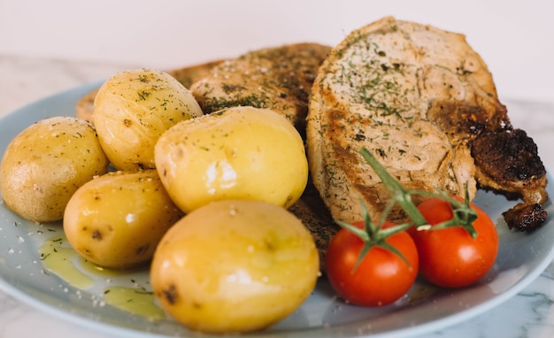 Varkenssteak met aardappelen en tomaten