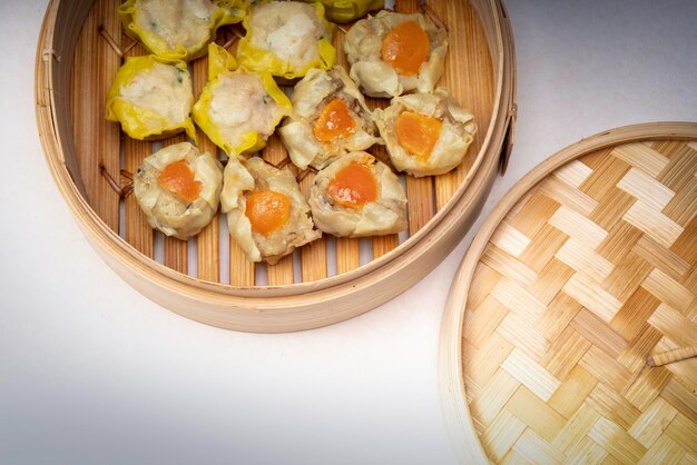 Varkensvlees en Krab Dumplings Klaar om te serveren in een oosterse geweven bamboe mand op een witte achtergrond