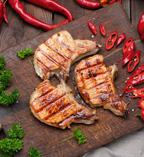 Varkensvlees gebakken biefstuk op de rib ligt op een vintage bruin houten bord