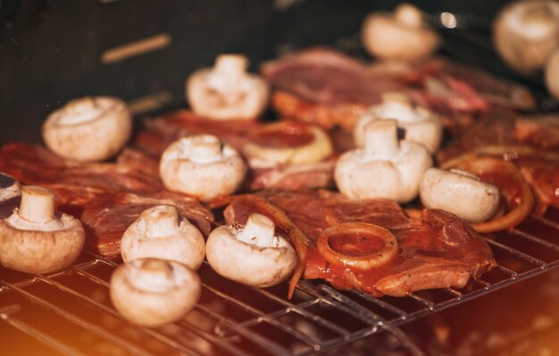 Varkensvlees in tomatensaus met uienringen en champignons koken buiten op de grill buitenbarbecue