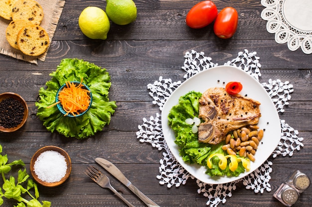 Varkensvlees steak zelfgemaakt koken met kruiden verlaat sla op houten snijplank, en een schotel,
