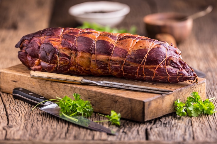 Foto varkensvlees. varkenskotelet gerookt. traditioneel gerookt vlees op eiken houten tafel in andere posities.