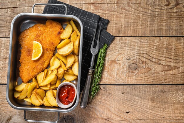 Varkensvlees Weiner Schnitzel Met Aardappelpartjes En Tomatensaus In Stalen Bak Houten Achtergrond Bovenaanzicht Kopieer ruimte