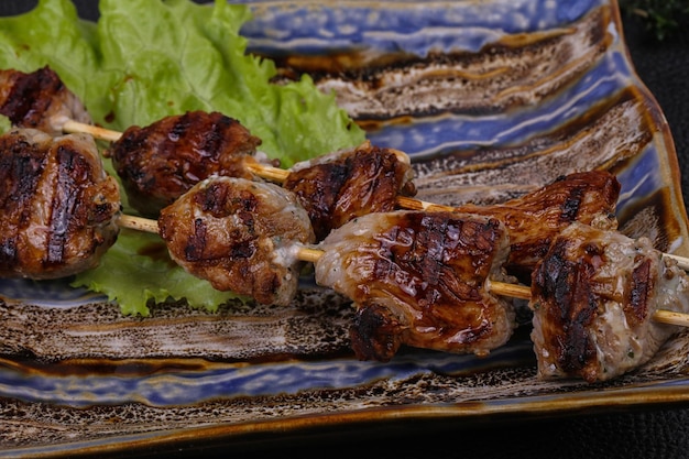 Varkensvleeskebabspiesjes in de plaat met slabladeren en tomaten