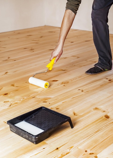 Varnishing wooden floor with roller