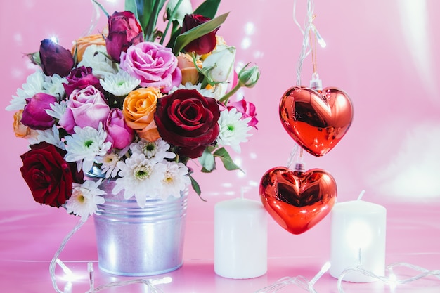 Vaso di bouquet rose, cuore rosso e candela bianca