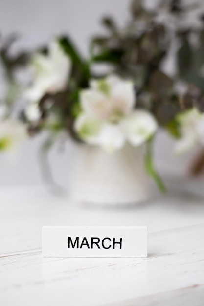 A vase of flowers with a sign that says march on it