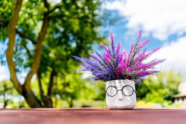 Foto vase in de vorm van een menselijk hoofd met lavendel op de achtergrond van de natuur