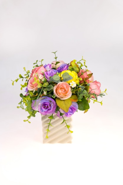 Photo vase plastic flowers in the room isolated on white background.