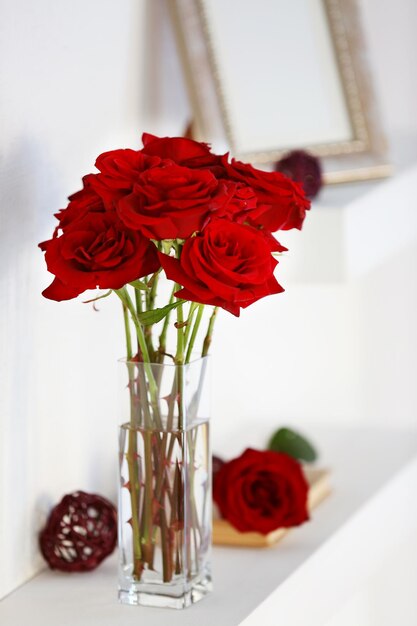 Vase of red roses on a shelf