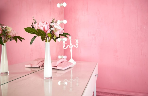 ピンクのインテリアのテーブルの上に花瓶。コピースペース。