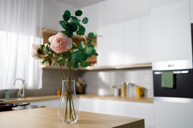 Vase with artificial flowers on the kitchen table