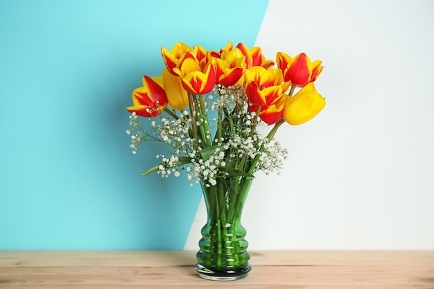 Vase with beautiful bouquet of spring flowers on wooden table