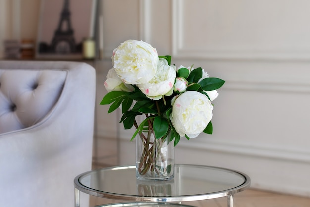 Vaso con bellissimi fiori di peonia sul tavolo