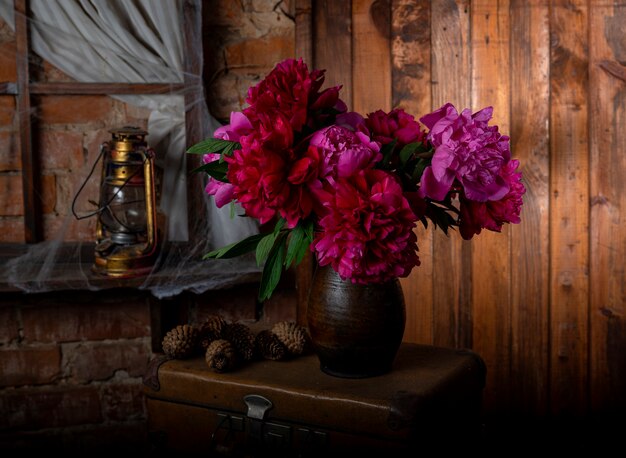 Vase with beautiful  red blooming peonies