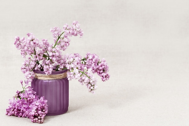 Vase with bouquet of lilac flowers