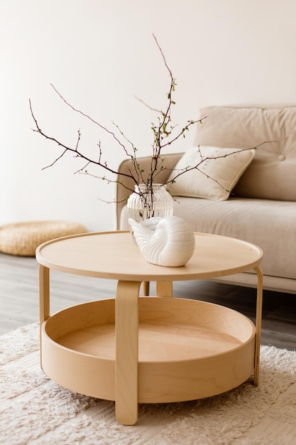 A vase with branches and a ceramic vase on a wooden table in the interior of the room