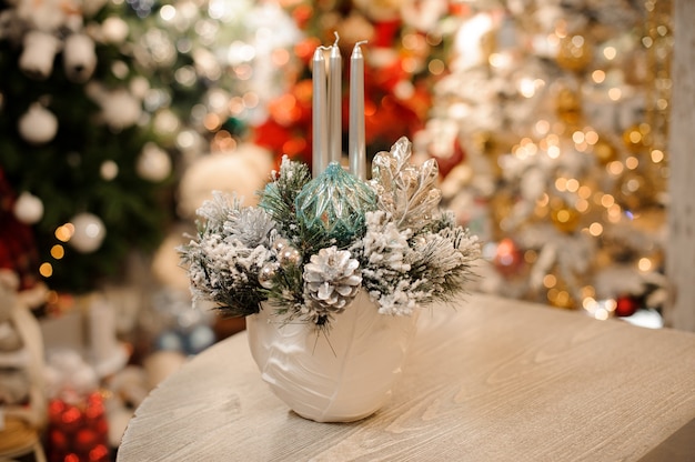 Vase with Christmas decor composition of flowers and candles