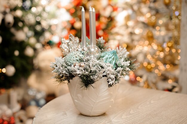 Vaso con composizione di decorazioni natalizie di fiori e candele