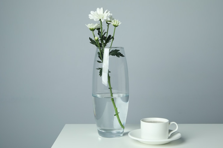 Photo 白いテーブルの上に菊とコーヒーのカップと花瓶。