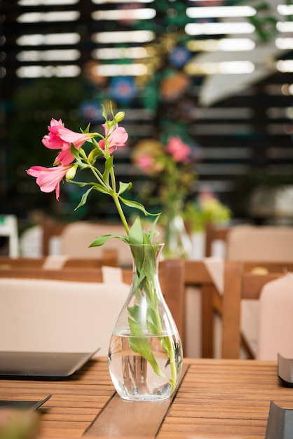 Vase with a flower on a table in a cafe