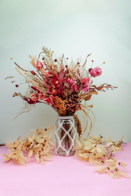 A vase with flowers and leaves on a table