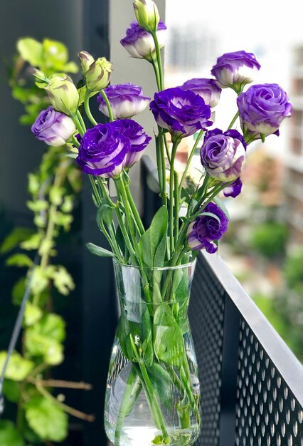 Photo a vase with purple flowers in it that is filled with water