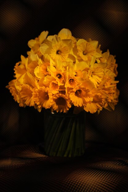 A vase of yellow flowers with the word daffodils on it