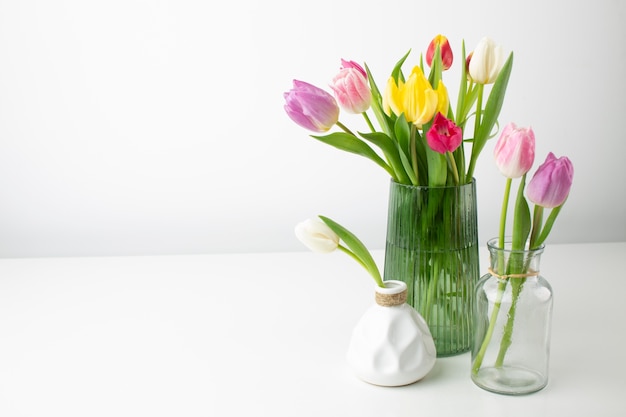 Vases with flowers on desk