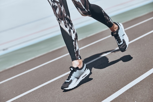 Vastbesloten om te winnen. Close up van jonge vrouw in sportschoenen jogging