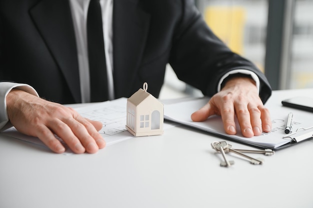 Vastgoedbedrijf om huizen en land te kopen levert sleutels en huizen aan klanten na akkoord te gaan met het sluiten van een overeenkomst voor de aankoop van een huis en het maken van een leningsovereenkomst Bespreking met een makelaar