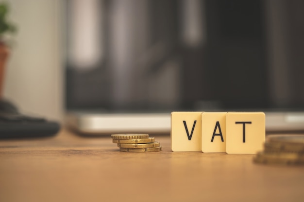 VAT concept. Word VAT and coins business desktop background with laptop. Business and investment photo