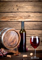 Vat, een fles en een glas rode wijn. op een houten achtergrond.