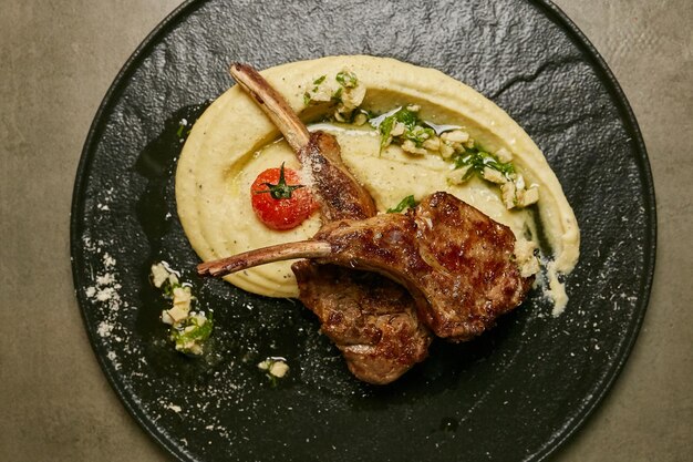 veal on the bone on a black plate photo of veal on the bone