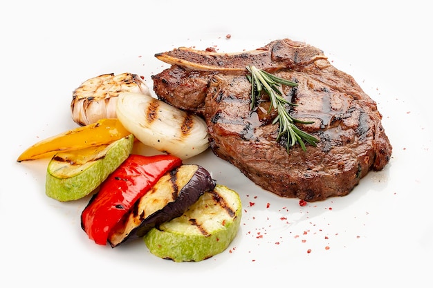 Veal bone steak with grilled vegetables on a white background