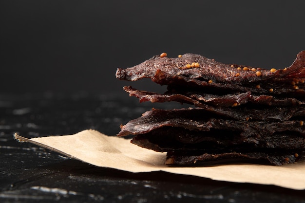 Veal jerky on craft paper and black background