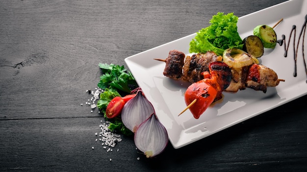송아지 고기 케밥 돼지 고기와 구운 야채 나무 배경 평면도 여유 공간