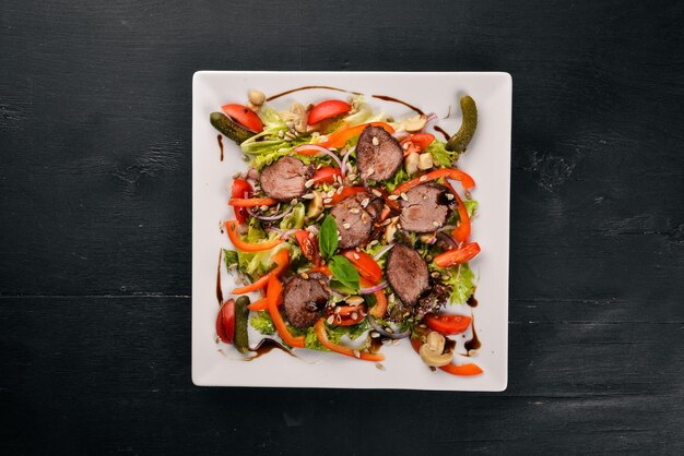 Veal Salad Lettuce and Fresh Vegetables on the plate On a wooden background Top view Free space for text