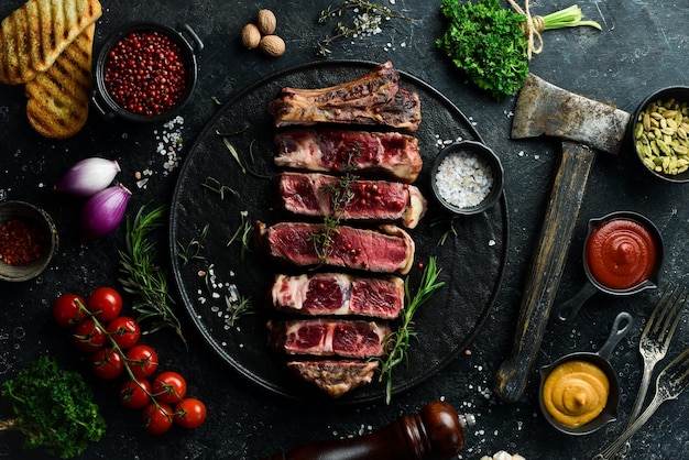 Bistecca di vitello con osso succosi pezzi di bistecca spazio libero per il testo vista dall'alto su uno sfondo di pietra nera