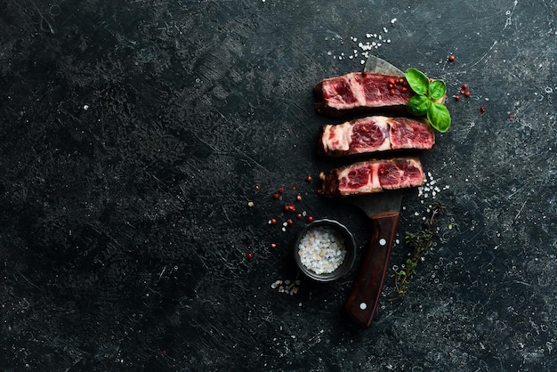 Veal steak on the knife Grill steak Free space for your text On a black stone background
