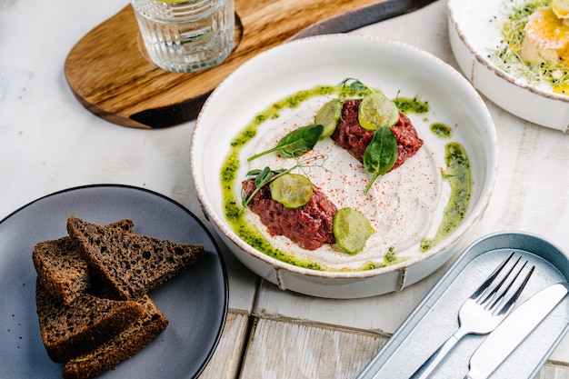 Veal tartar with truffle sauce pickled cucumber and dark bread