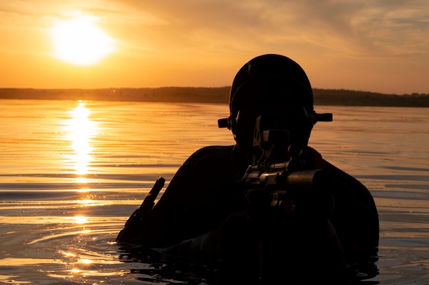 Vechter van een speciale eenheid verlaat het water en bereidt zich voor op de start van de operatie. Gemengde media. Het concept van instabiliteit in de wereld, vijandelijkheden, crisis. Rusland vs VS