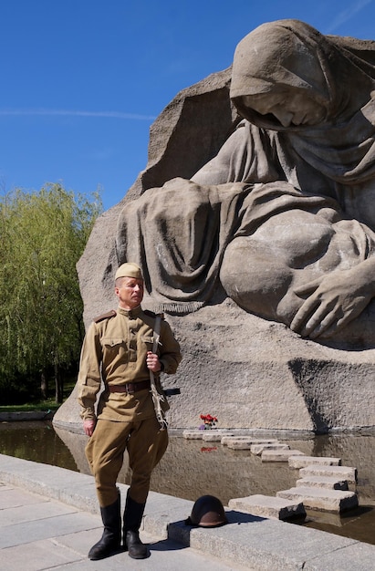 Vechter van het Rode Leger in de vorm van tijden van de Tweede Wereldoorlog met het machinegeweer bij een historisch monument op Mamajev Koergan in Volgograd