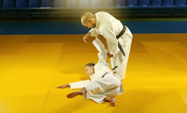 Vechtsporten. Portiers sparen. Sportman en vrouw in witte kimono trainen judoworpen en vangt in de sporthal