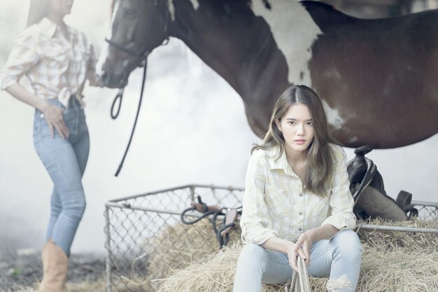 Foto veedrijfster werkende stallen. concept van retro vrouw in paard ranch. vintage stijl