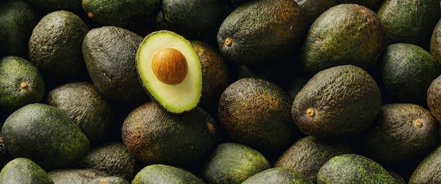 Veel avocado's met gehalveerde avocado met zaden in een stapel, veganistisch eten