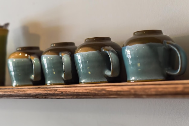 Veel blauwe kopjes op een rij op de houten plank in de keuken